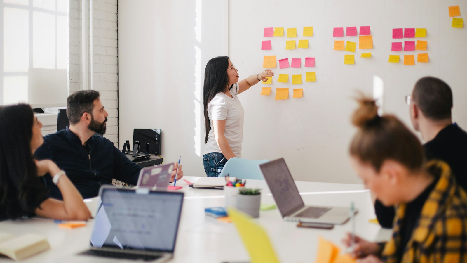 Equip treballant en la millora de processos amb notes adhesives